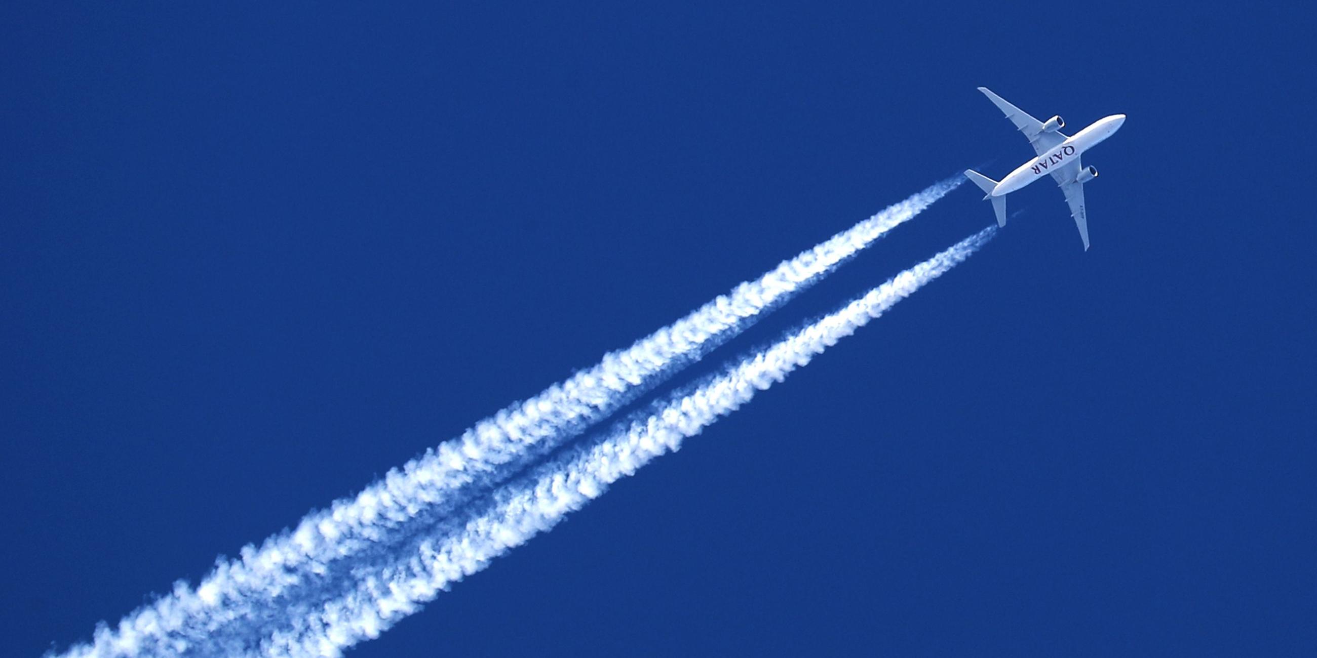 Ein Flugzeug hinterlässt Kondensstreifen am wolkenlosem Himmel