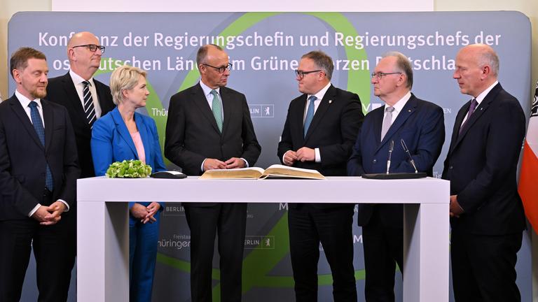 Michael Kretschmer (l-r, CDU), Ministerpräsident von Sachsen, Dietmar Woidke (SPD), Ministerpräsident von Brandenburg, Manuela Schwesig (SPD), Ministerpräsidentin von Mecklenburg-Vorpommern, Bundeskanzler Friedrich Merz (CDU), Mario Voigt (CDU), Ministerpräsident von Thüringen, Reiner Haseloff (CDU), Ministerpräsident von Sachsen-Anhalt, und Kai Wegner (CDU), Regierender Bürgermeister von Berlin, stehen auf Schloss Ettersburg beisammen.
