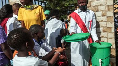 Ein Diakon hilft jungen Gemeindemitgliedern beim Händewaschen vor dem Betreten der Kirche in Bunia, 24. Mai 2026.