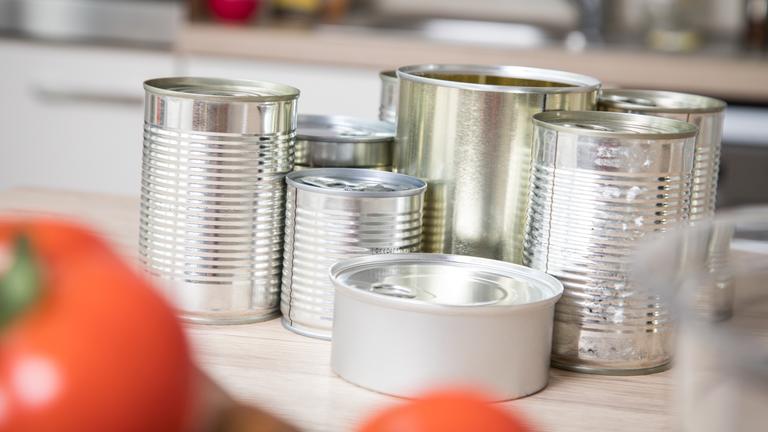 Konservendosen ohne Etikett stehen auf der Arbeitsfläche einer Küche.