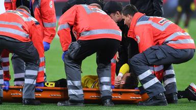 Konstantinos Karetsas wird verletzt von Notfallsanitätern vom Platz getragen.