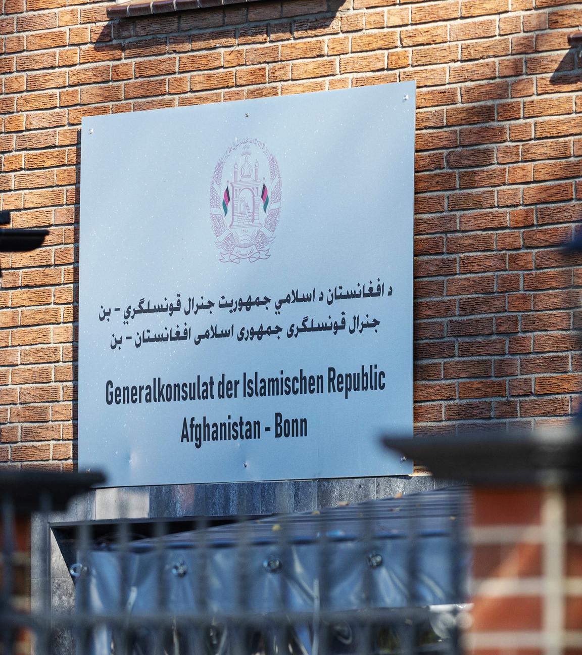 Ein Schild mit Informationen hängt an einer Hauswand.