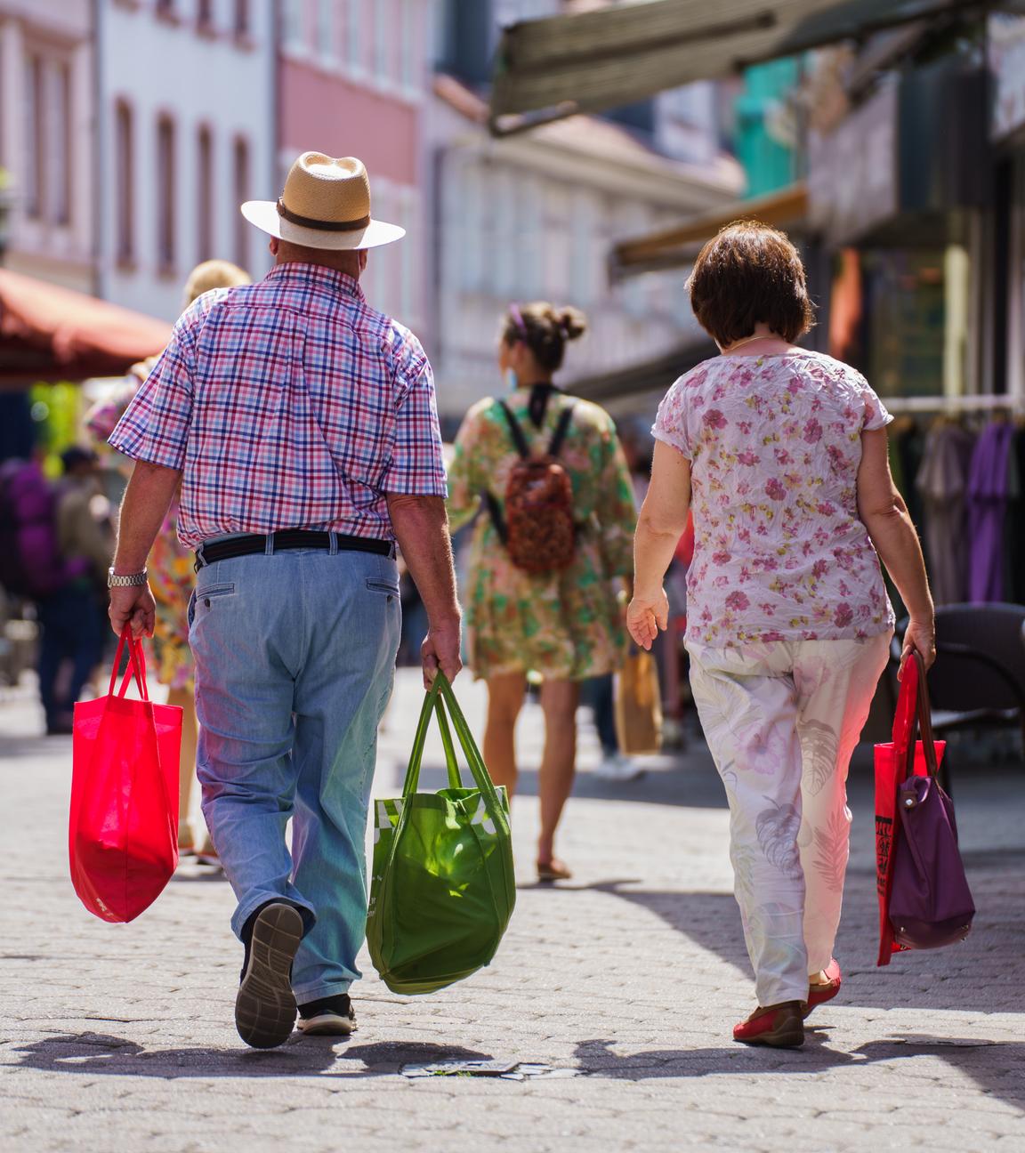 Ein Mann und eine Frau gehen durch die Steingasse in Aschaffenburg. Sie tragen Einkaufstüten und sind von hinten zu sehen.