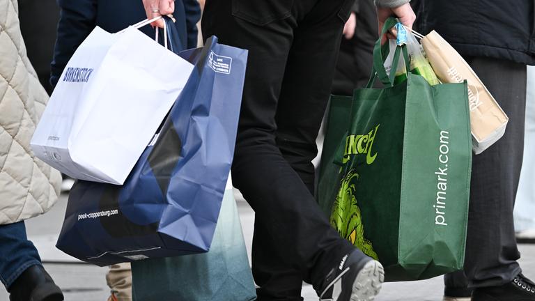 Ein Mann geht mit Tüten bepackt über die Frankfurter Einkaufsstraße Zeil.