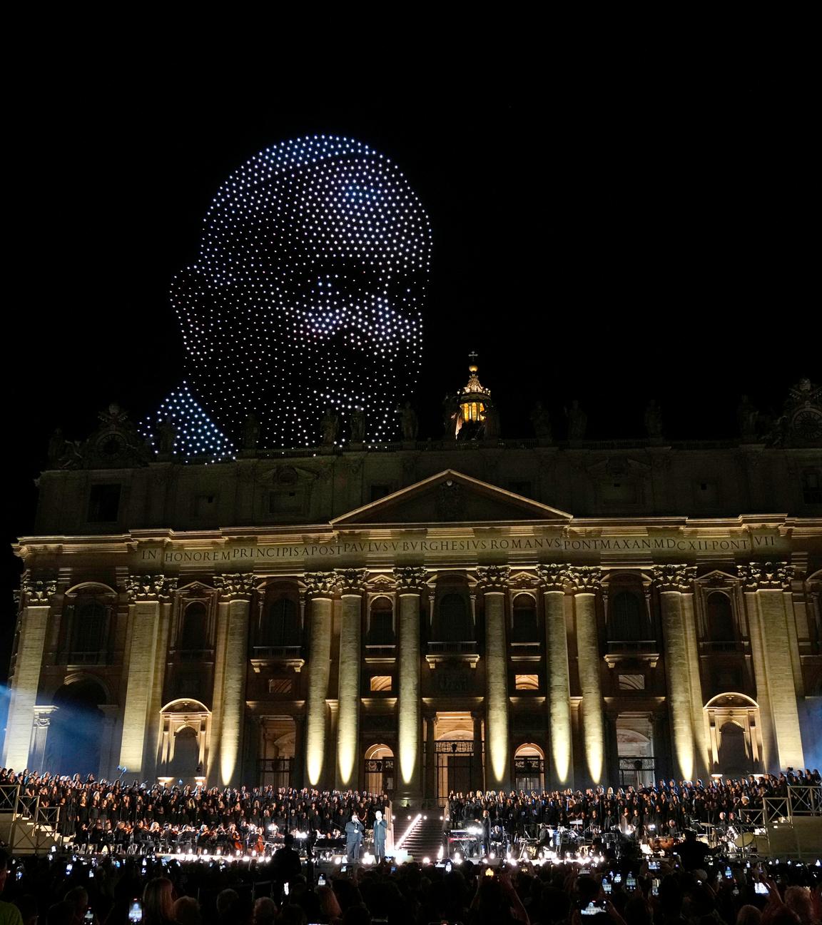 Vatikan, Vatikanstadt: Ein Bild von Papst Franziskus, das von Drohnen über dem Petersdom erstellt ist, erscheint während eines Konzerts auf dem Petersplatz zum Abschluss des Welttreffens über menschliche Brüderlichkeit im Vatikan.