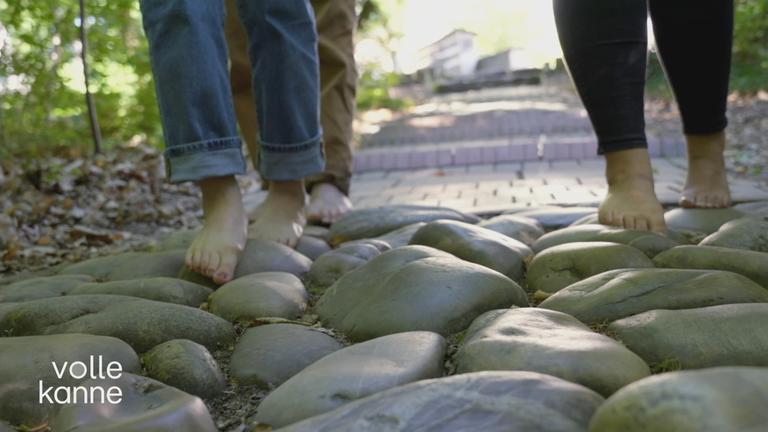 zwei Personen auf einem Barfußpfad
