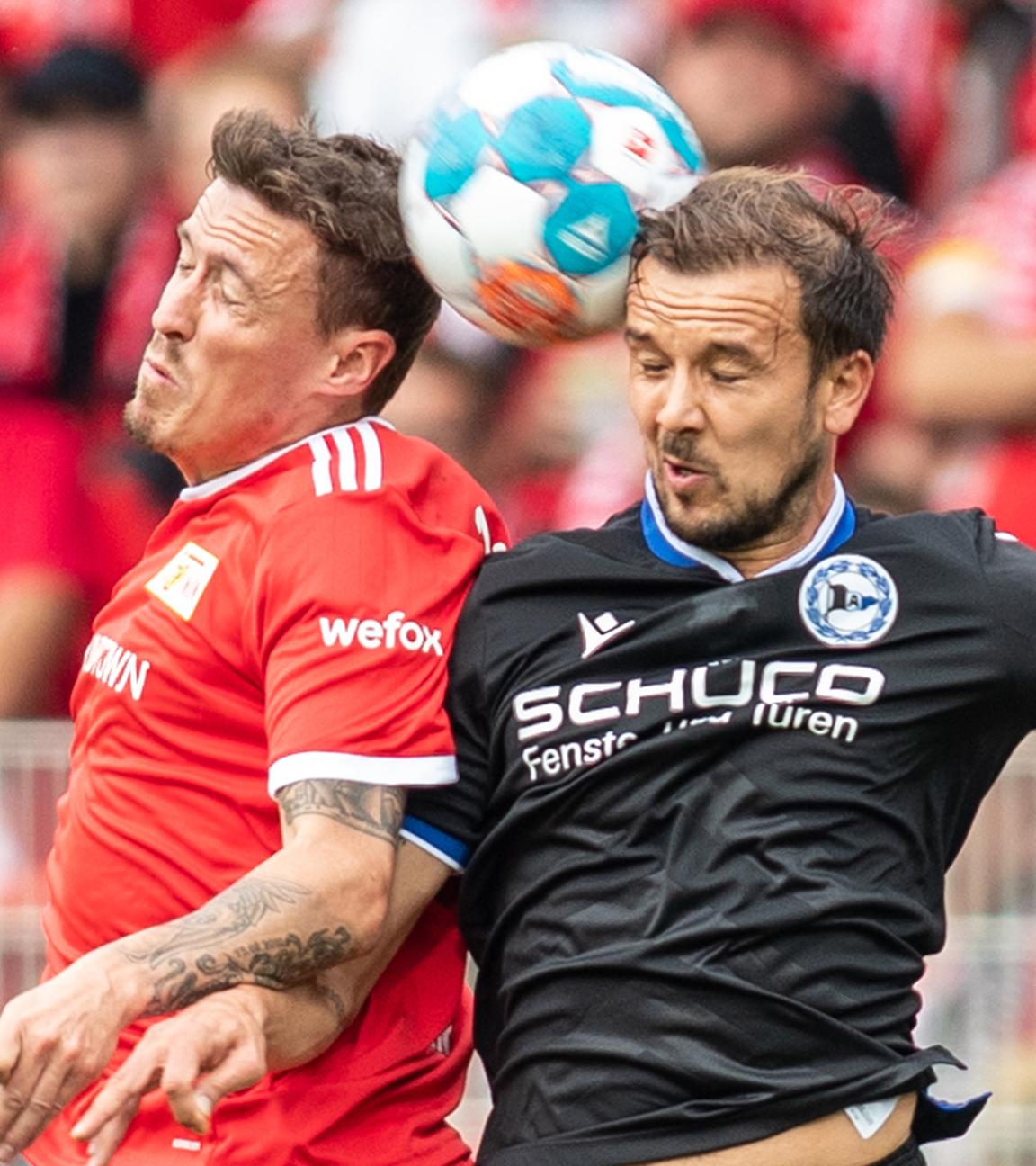 Berlins Max Kruse (l) springt zum Kopfball gegen Manuel Prietl von Arminia Bielefeld.
