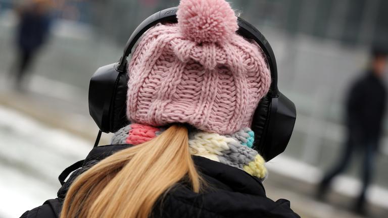 Symbolbild: Junge Frau mit Mütze und Kopfhörern