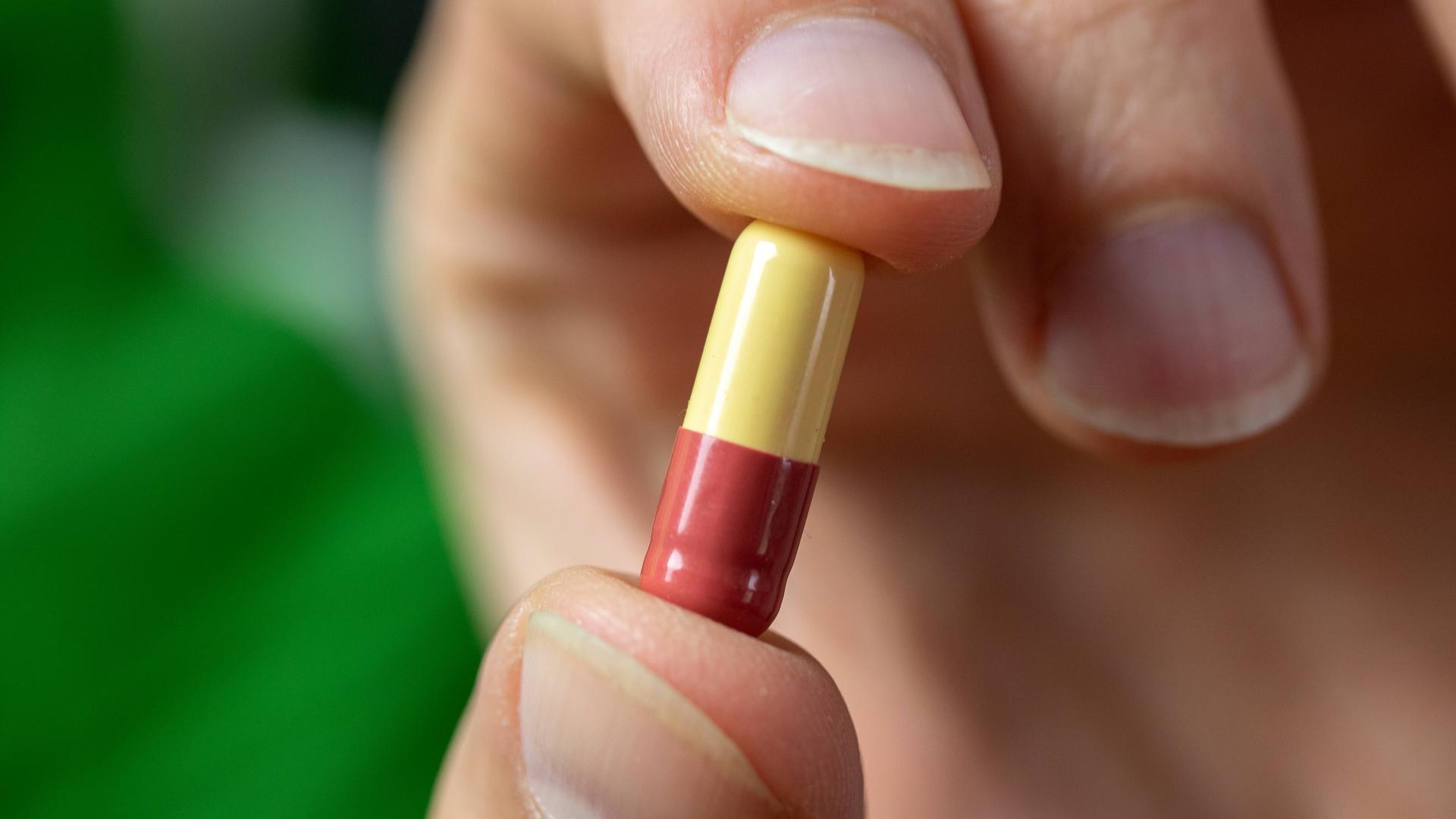 Tablette wird mit zwei Fingern gehalten