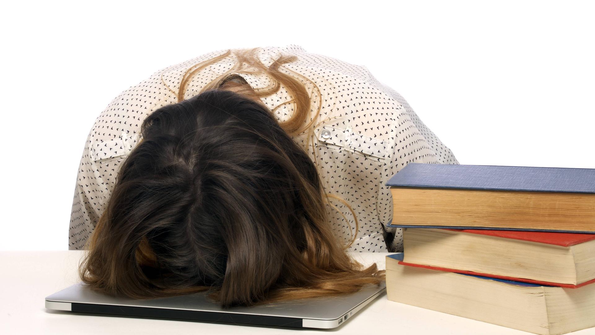 Frau liegt mit ihrem Kopf auf einem Tisch