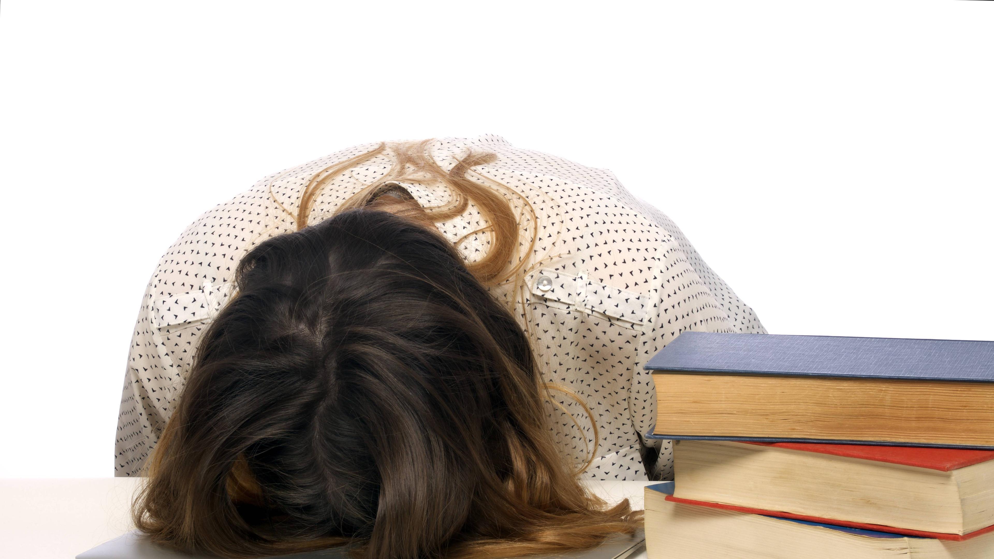 Frau liegt mit ihrem Kopf auf einem Tisch