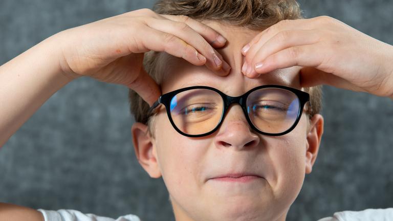 Symbolbild: Ein Junge hat Kopfschmerzen