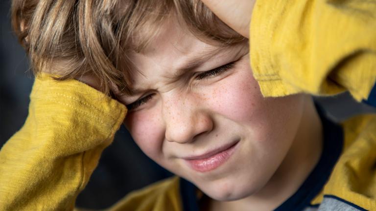 Symbolbild: Kind mit mit schmerzverzerrtem Gesicht 