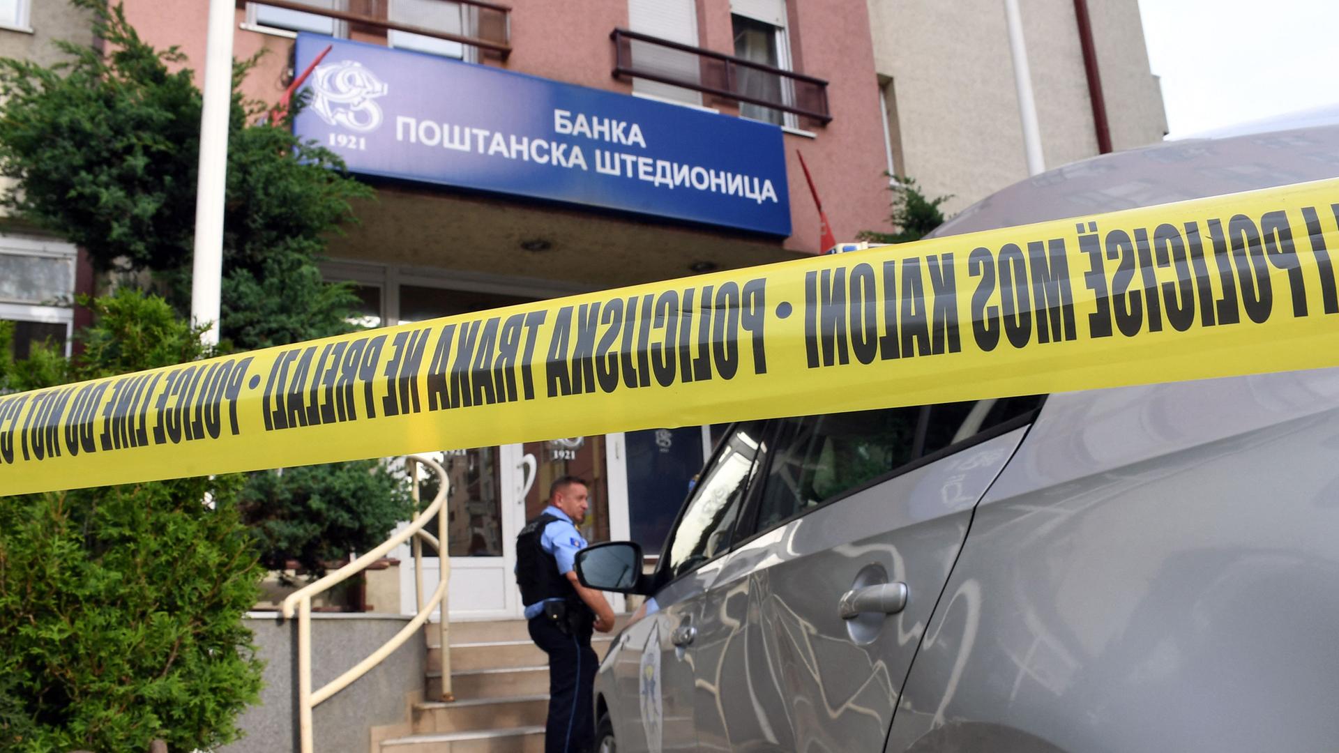Ein kosovarischer Polizist bewacht ein Büro der serbischen "Postsparkasse".