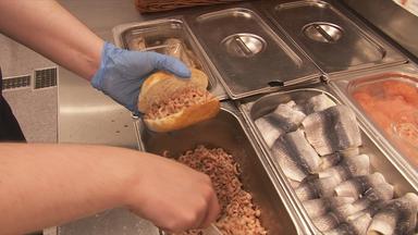 Verkäuferin belegt Krabbenbrötchen