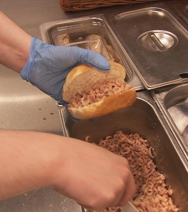 Verkäuferin belegt Krabbenbrötchen