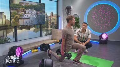Florian Weiss macht eine Kniebeuge und Dr. Christoph Lambert steht daneben 