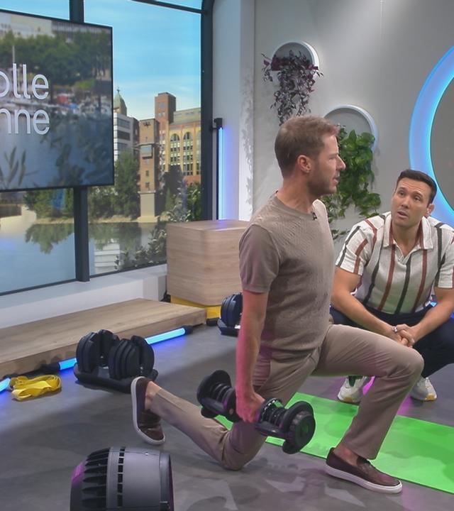 Florian Weiss macht eine Kniebeuge und Dr. Christoph Lambert steht daneben 