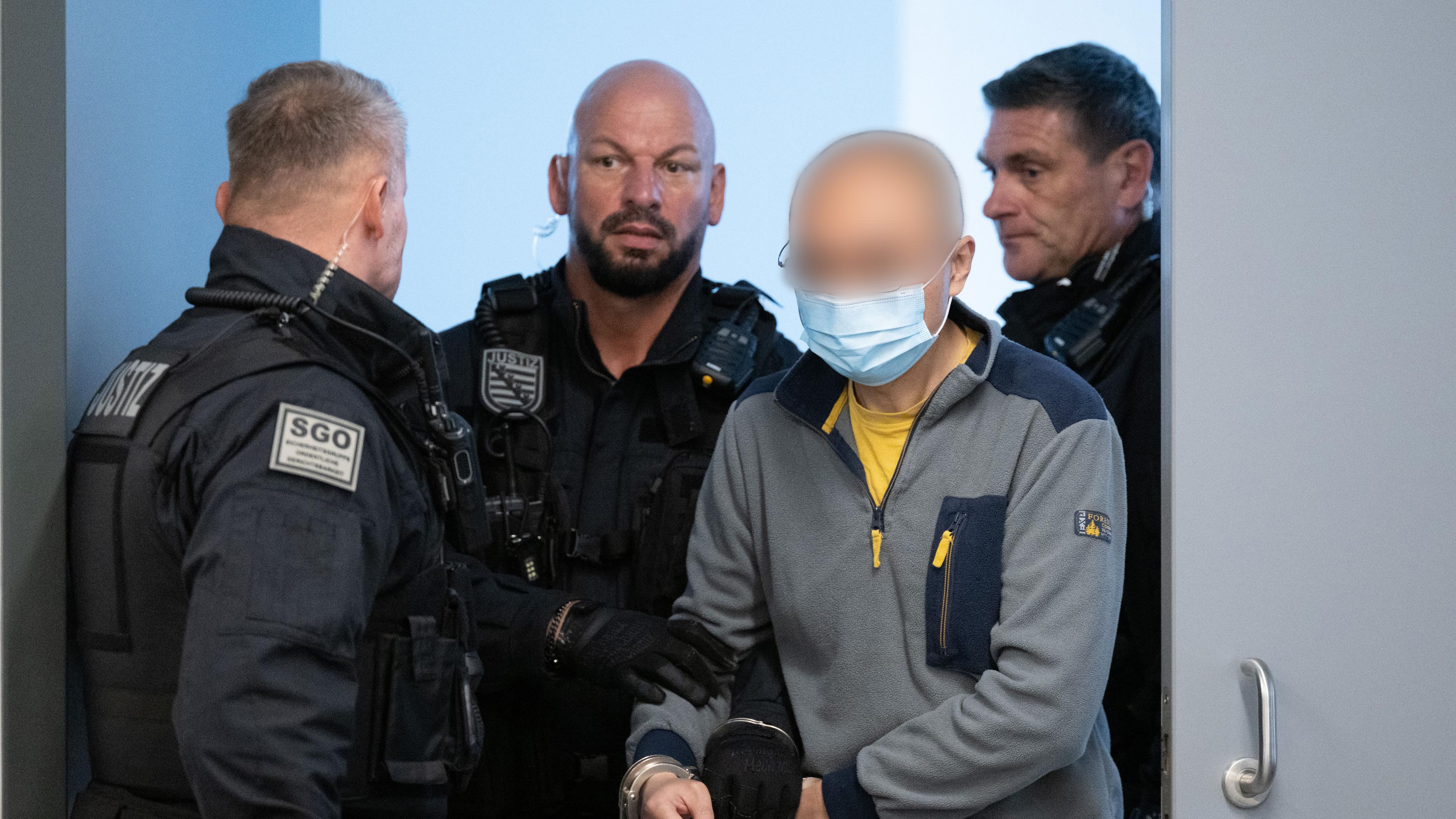 Der Hauptangeklagte Jian G. (2.v.r.) im Spionageprozess wird vor Prozessbeginn in den Gerichtssaal geführt. 