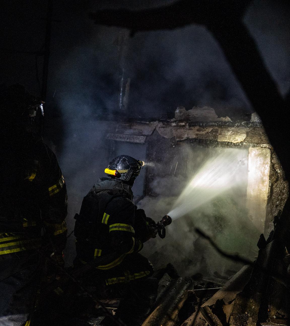 Ukrainische Feuerwehrleute löschen ein Feuer in einem Privathaus, das von einer russischen Drohne getroffen wurde.