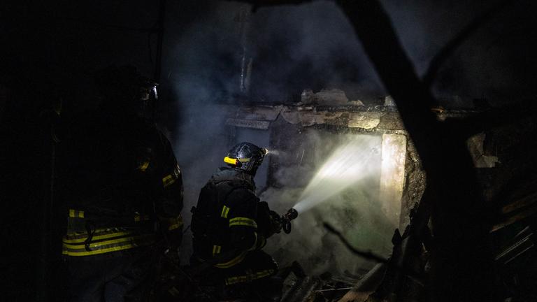 Ukrainische Feuerwehrleute löschen ein Feuer in einem Privathaus, das von einer russischen Drohne getroffen wurde.