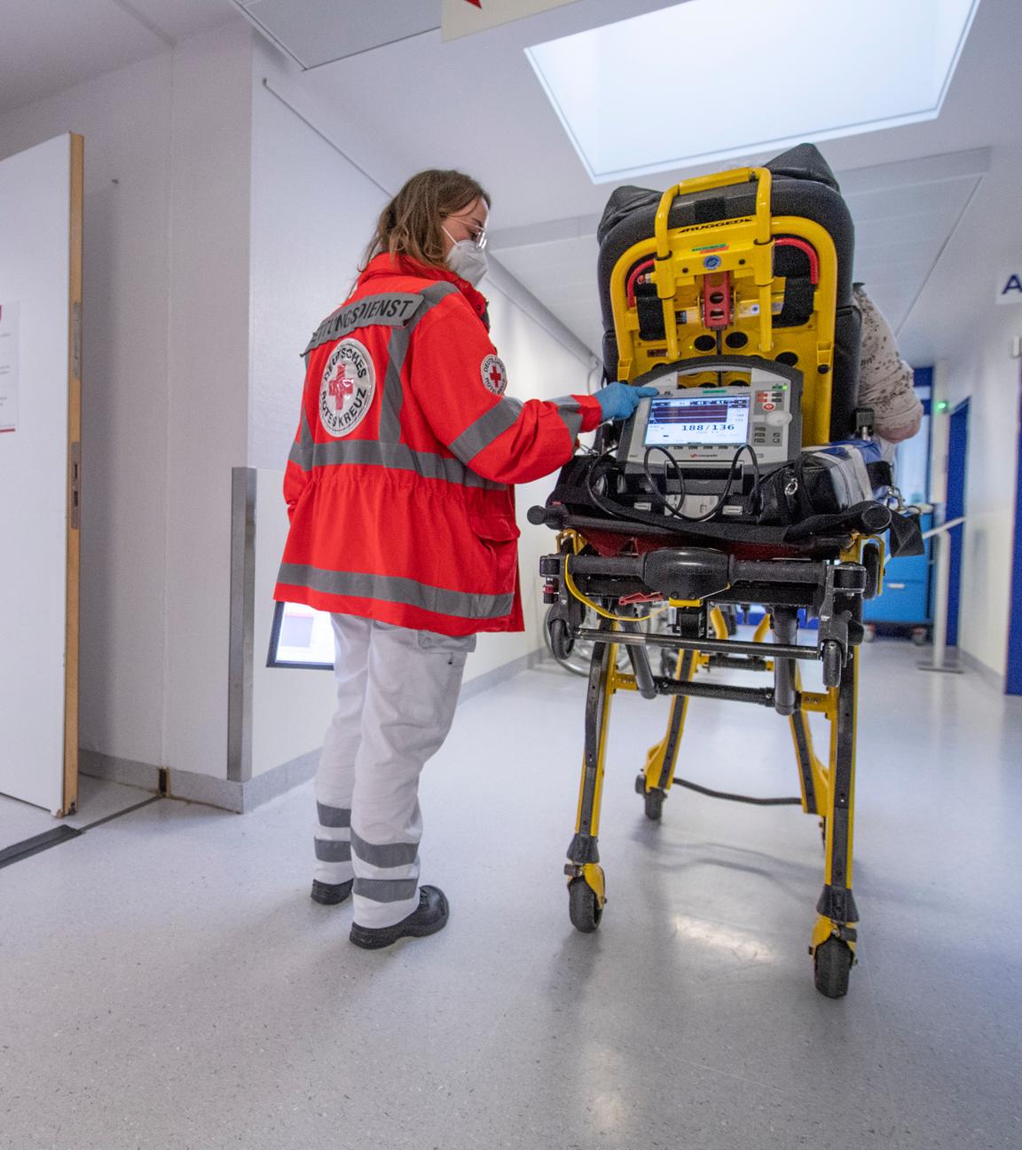 Eine Sanitäterin schiebt eine Patientin über den Krankenhausflur