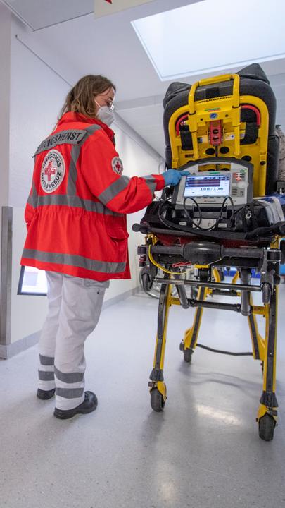 Eine Sanitäterin schiebt eine Patientin über den Krankenhausflur