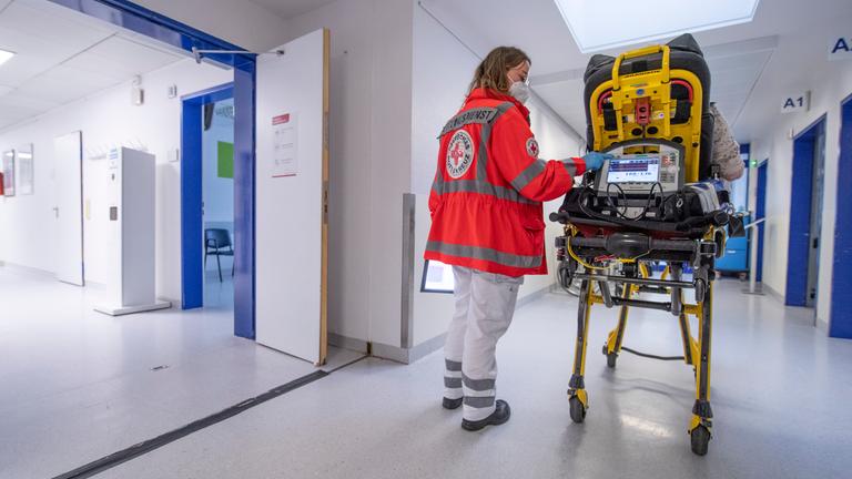 Eine Sanitäterin schiebt eine Patientin über den Krankenhausflur