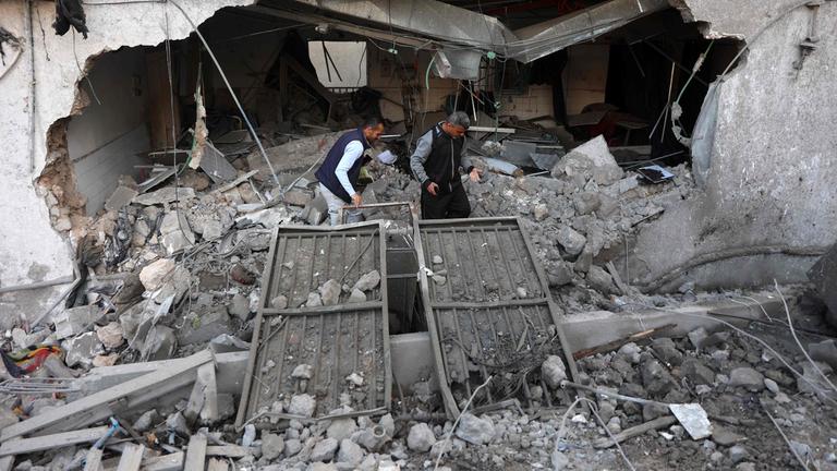 Zwei Männern stehen in den Trümmern des Al-Ahli-Krankenhauses in Gaza-Stadt, nachdem dieses von einem israelischen Angriff zerstört wurde.