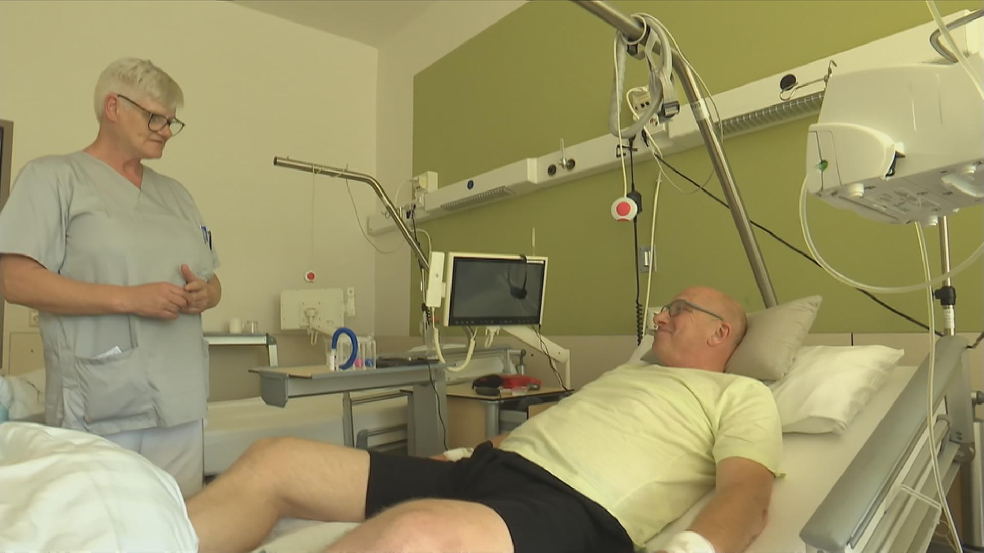 Mann liegt im Krankenhausbett