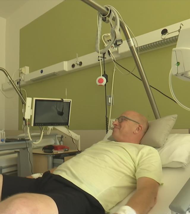 Mann liegt im Krankenhausbett