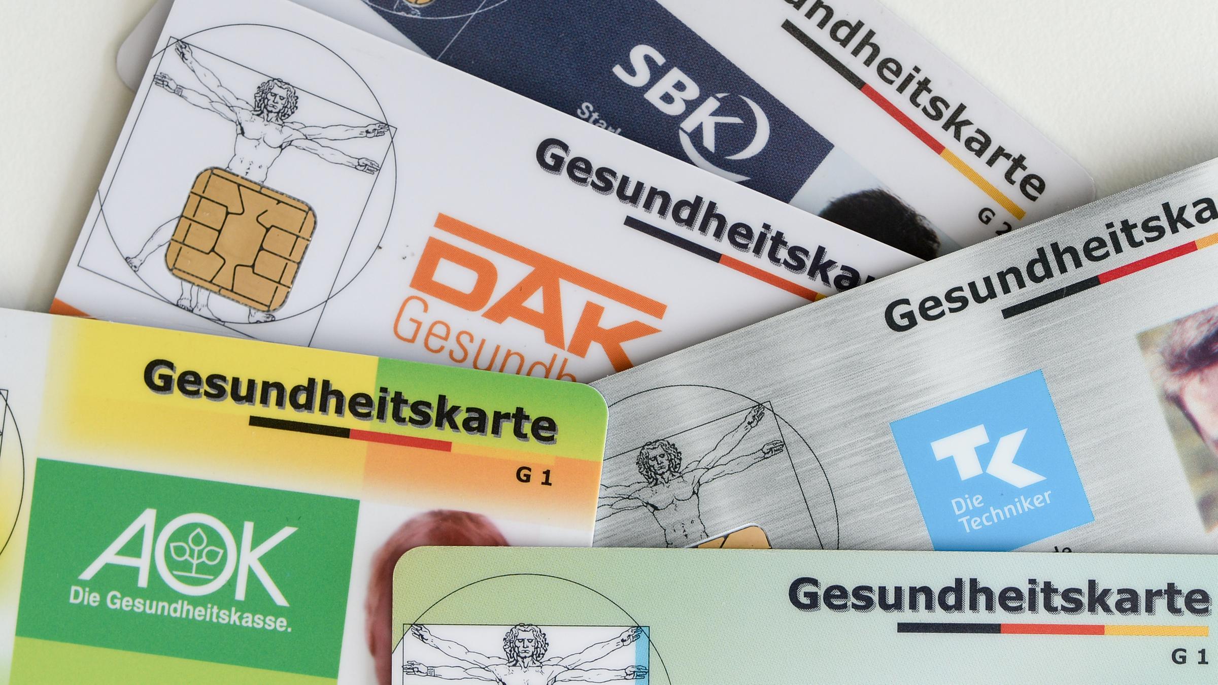 Berlin: Gesundheitskarten verschiedener Krankenkassen liegen auf einem Tisch.