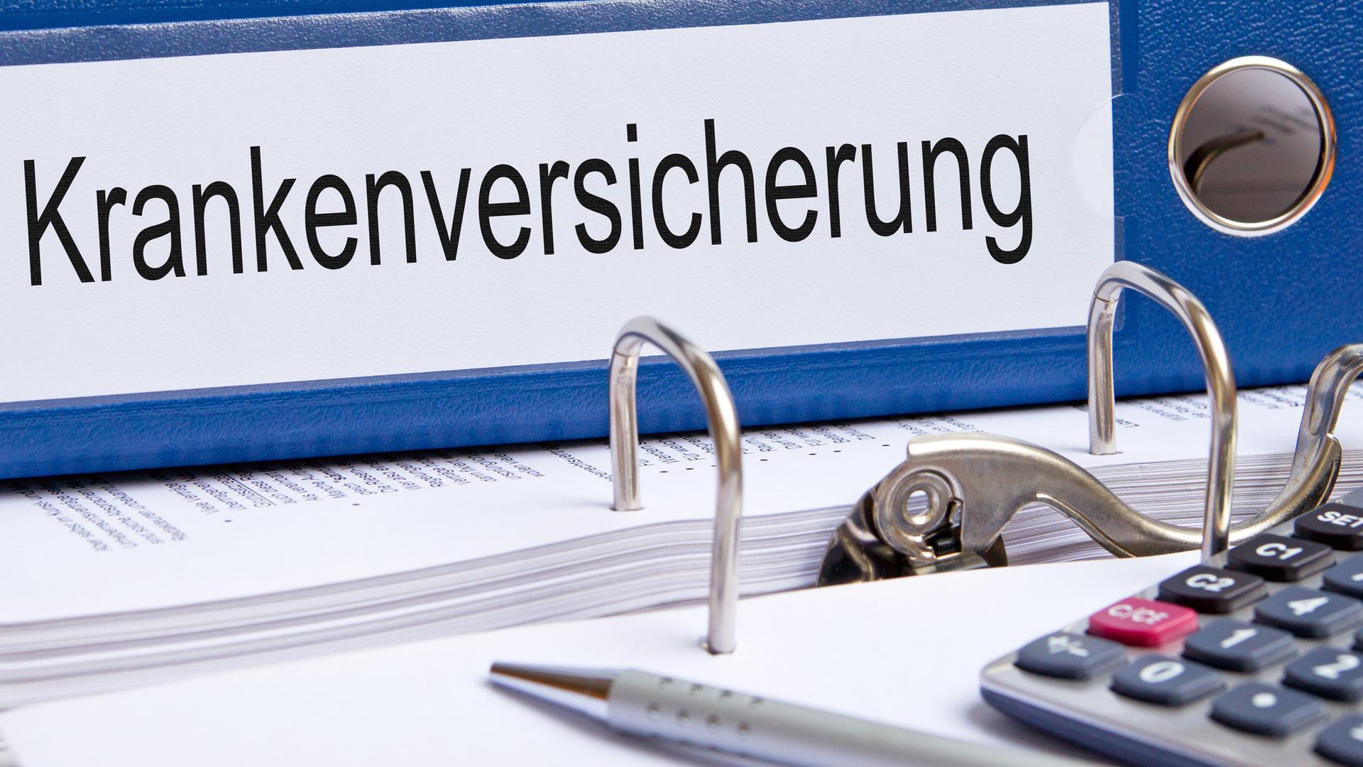 Ein Ordner mit der Aufschrift" Krankenkasse" liegt auf einem Tisch. 