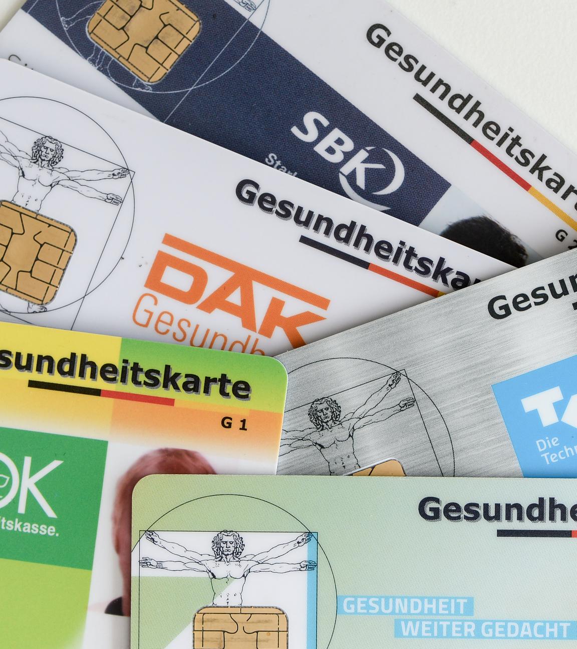Symbolbild: Gesundheitskarten verschiedener Krankenkassen liegen auf einem Tisch. 