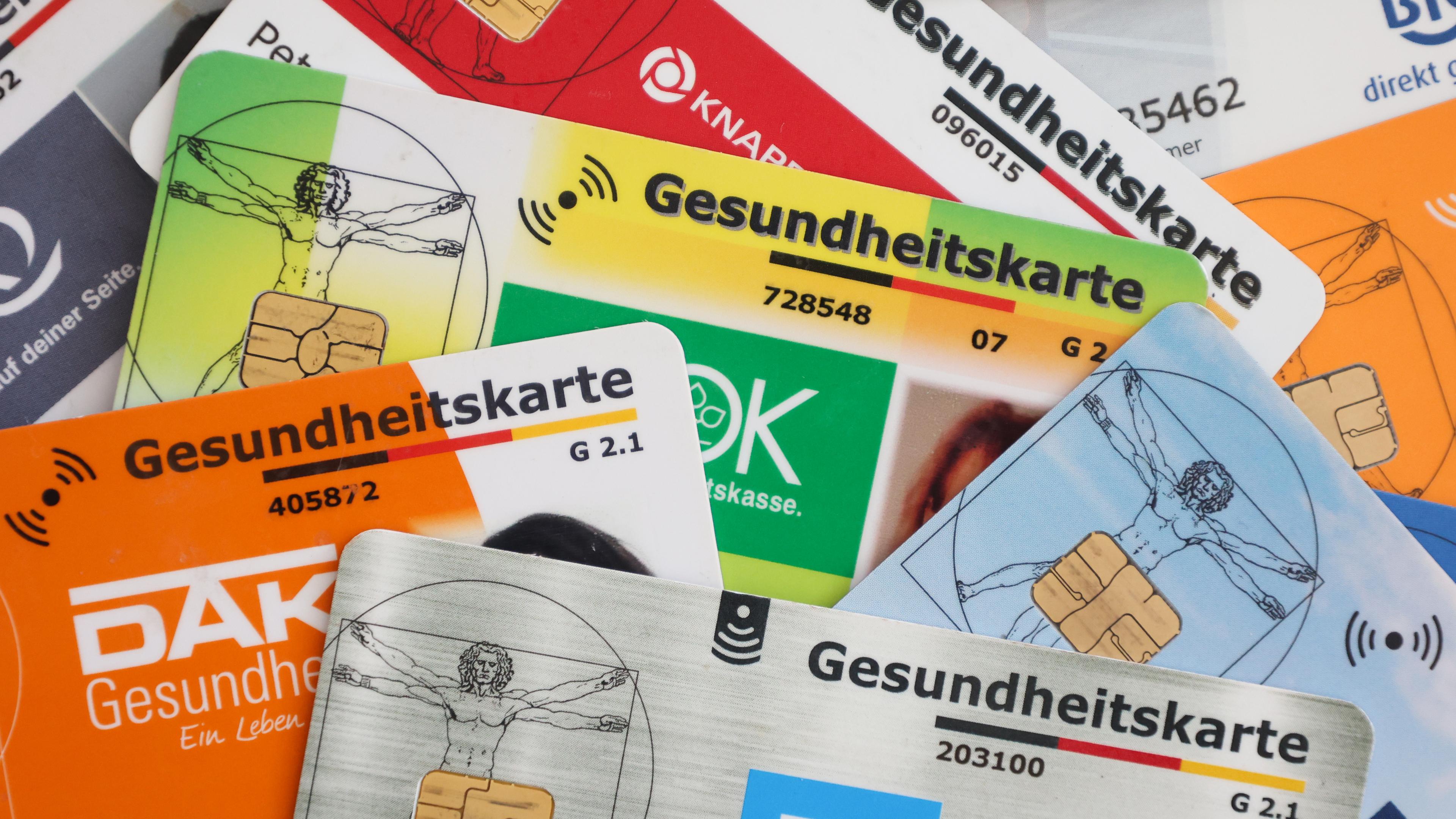 Eine Auswahl an Gesundheitskarten gesetzlicher Krankenkassen in Deutschland. Die elektronische Gesundheitskarte (eGK) dient als Versicherungsnachweis beim Arztbesuch und enthält persönliche Versichertendaten.