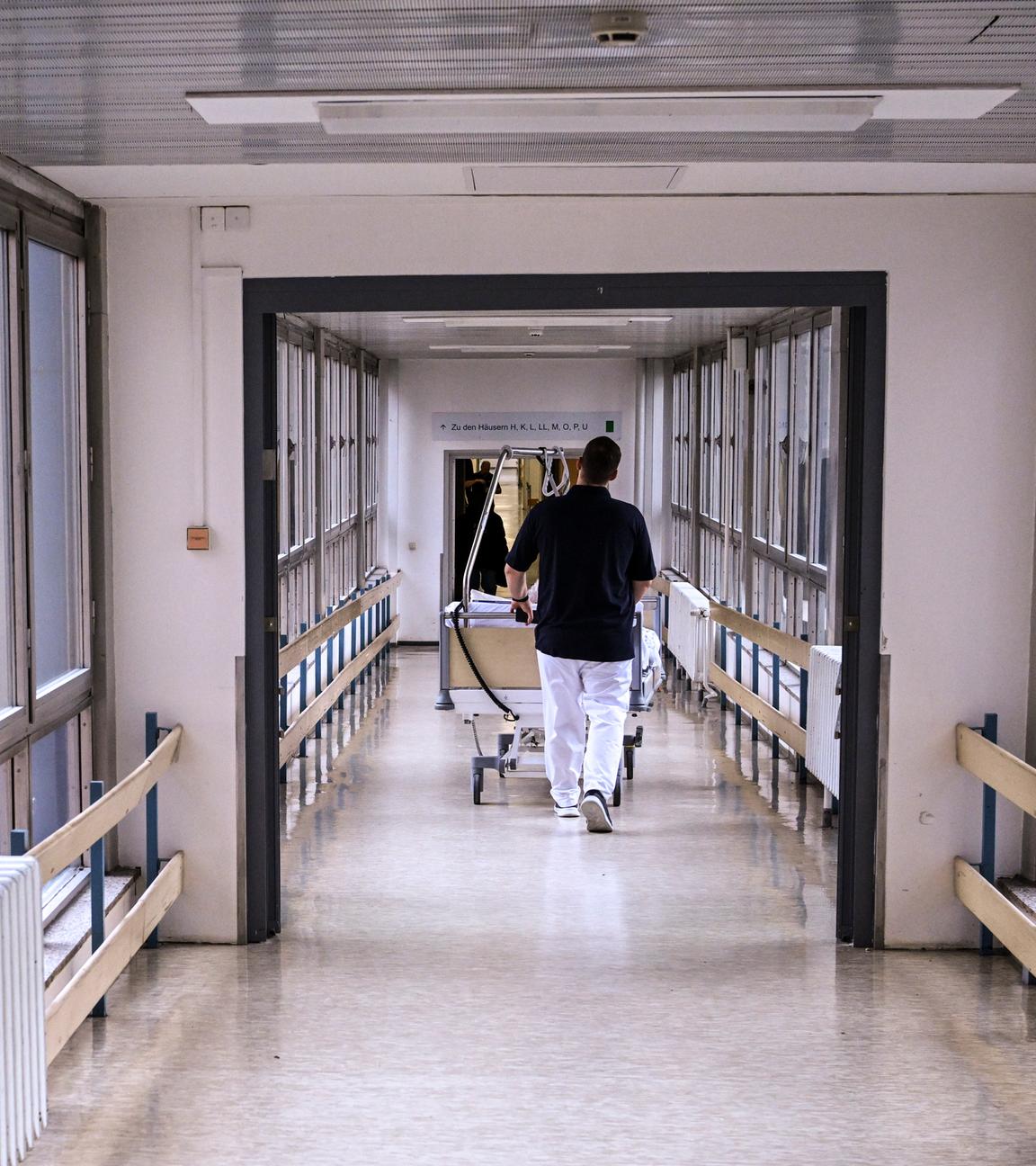 Ein Patientenbett wird durch einen Krankenhausflur geschoben.
