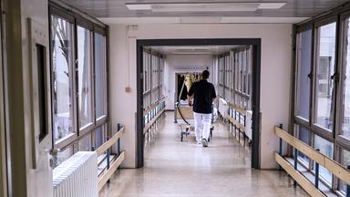 Ein Patientenbett wird durch einen Krankenhausflur geschoben.