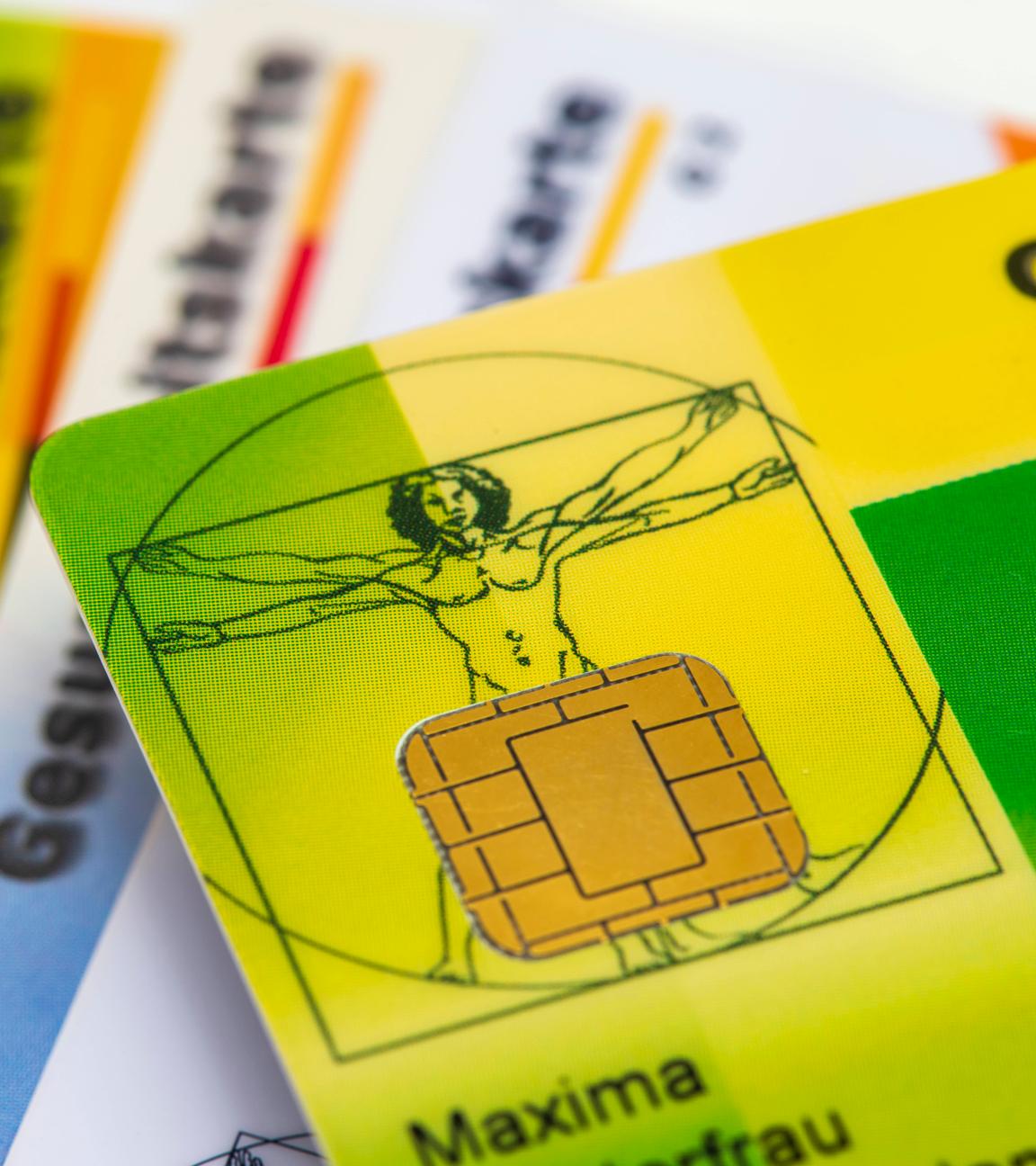Viele bunte Gesundkeitskarten von verschiedenen Krankenkassen liegen zusammen