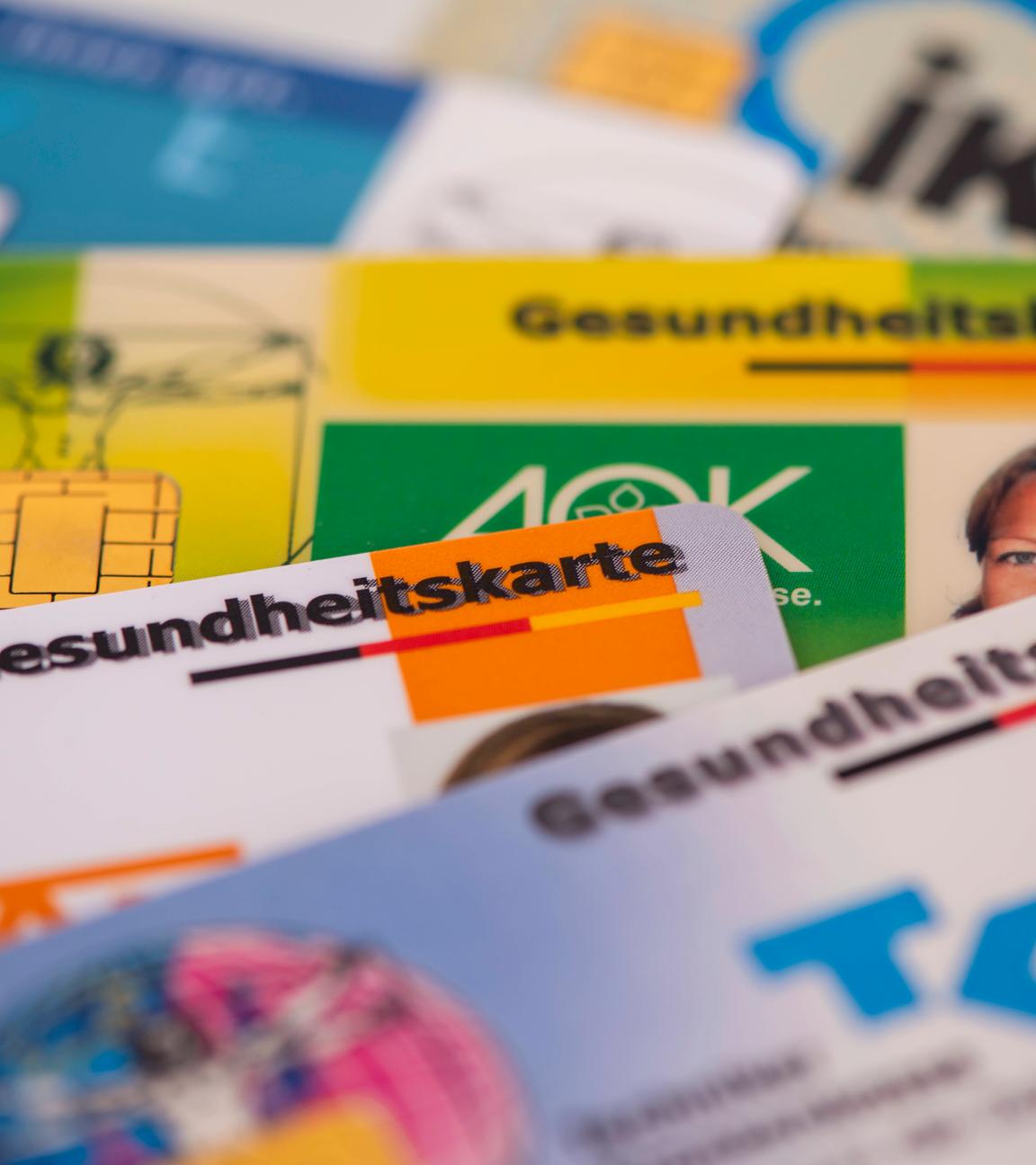 Mehrere Gesundheitskarten von verschiedenen Krankenkassen liegen zusammen