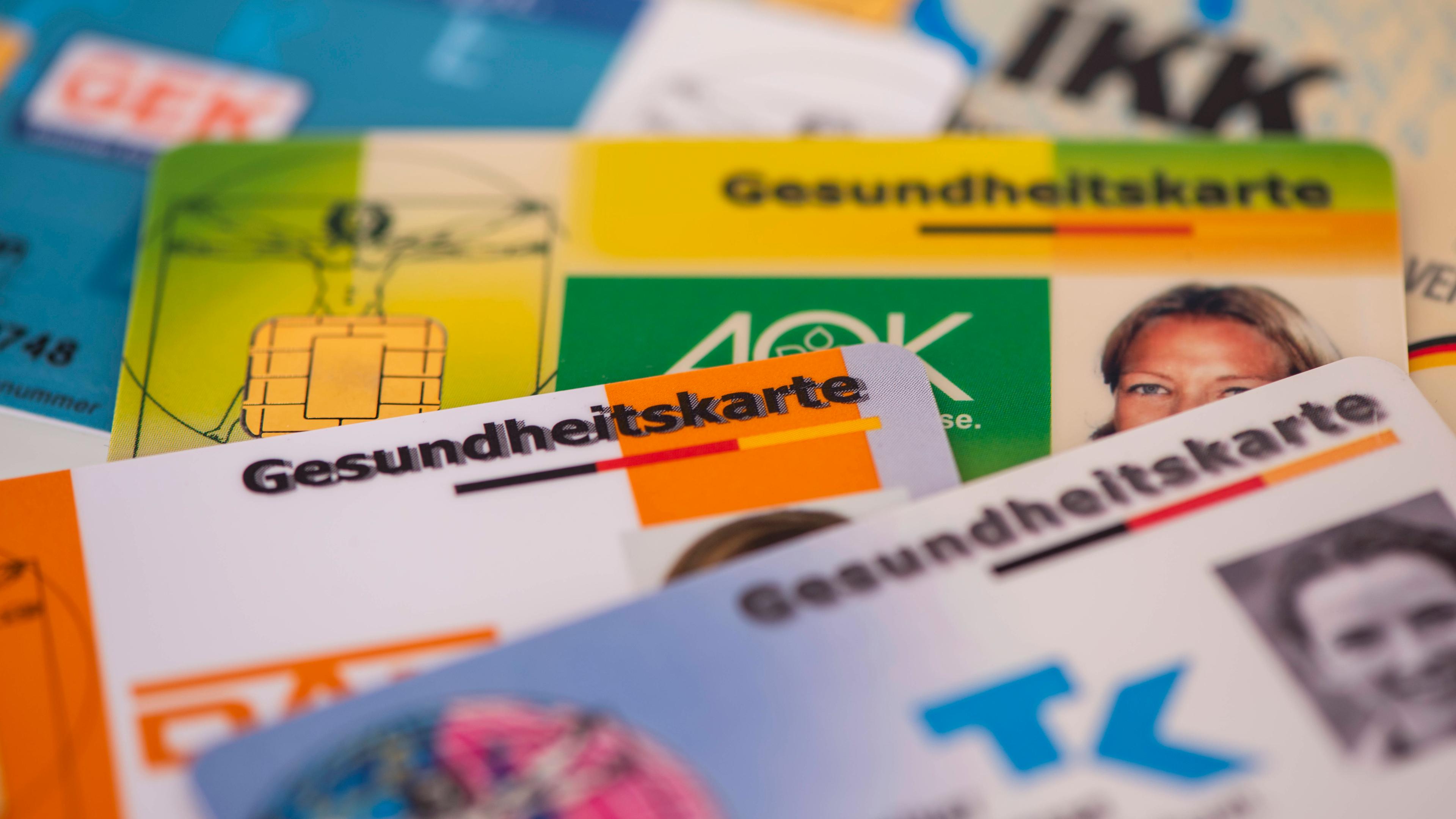 Mehrere Gesundheitskarten von verschiedenen Krankenkassen liegen zusammen