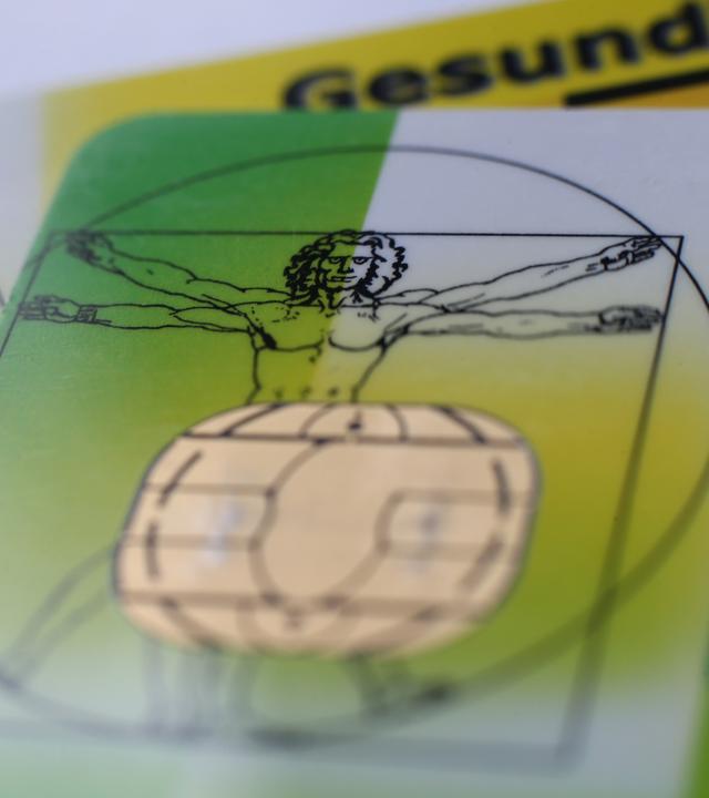 Zwei elektronische Versichertenkarten der Allgemeinen Ortskrankenkassen (AOK) liegen auf einem Tisch. 