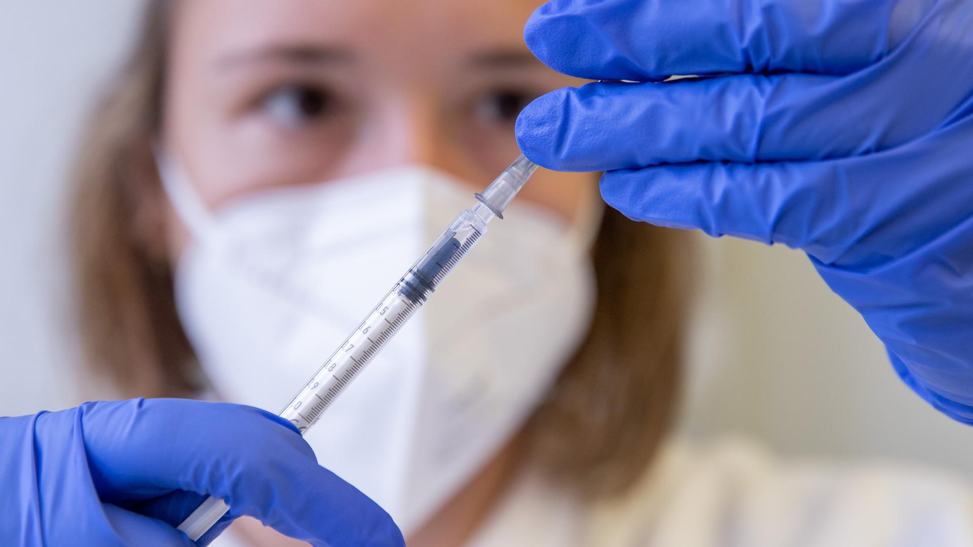 Eine Pflegekraft zieht eine Spritze auf (Symbolbild für Pflegebeiträge).