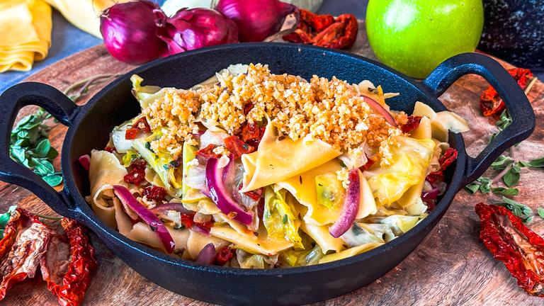 Nudeln mit Spitzkohl in einer Pfanne serviert.