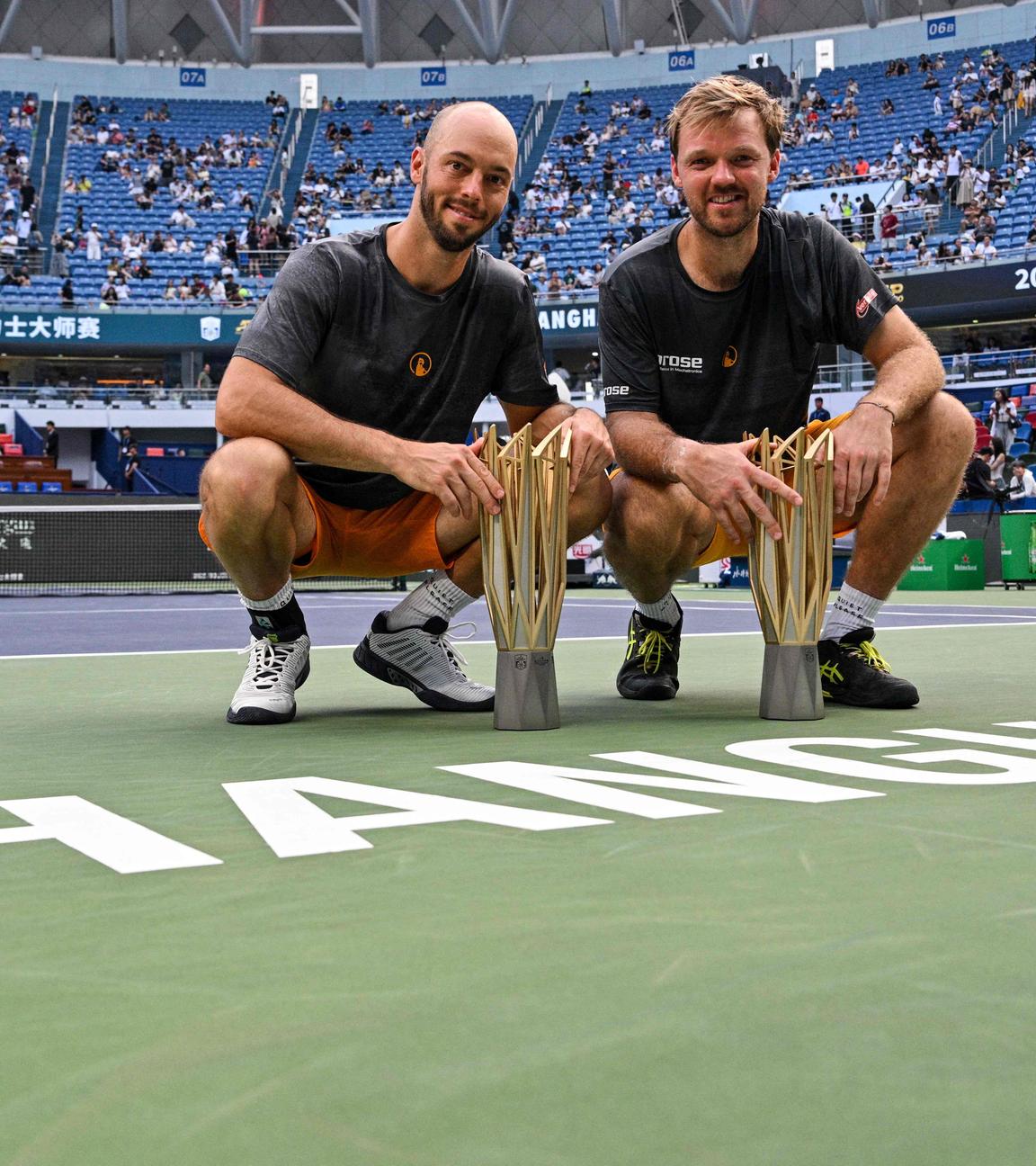 Tim Pütz (links) und sein Doppelpartner Kevin Krawietz sind auf dem Court in Shanghai in die Hocke gegangen. Vor ihnen ihr Siegerpokal.