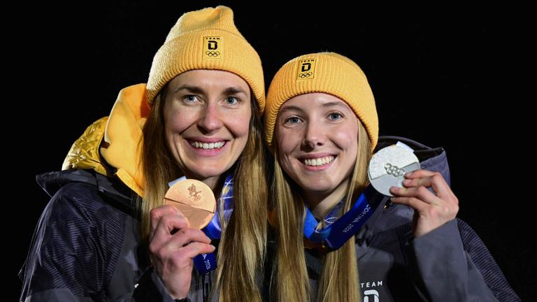 Die deutschen Skeletonpilotinnen Jacqueline Pfeifer und Susanne Kreher präsentieren ihre beiden Medaillen bei den Olympischen Winterspielen 2026 in Cortina
