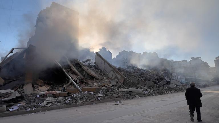 Ein Mann geht in Beirut, Libanon, an einem Gebäude vorbei, aus dem Rauch aufsteigt. Es wurde von einem israelischen Luftangriff getroffen.