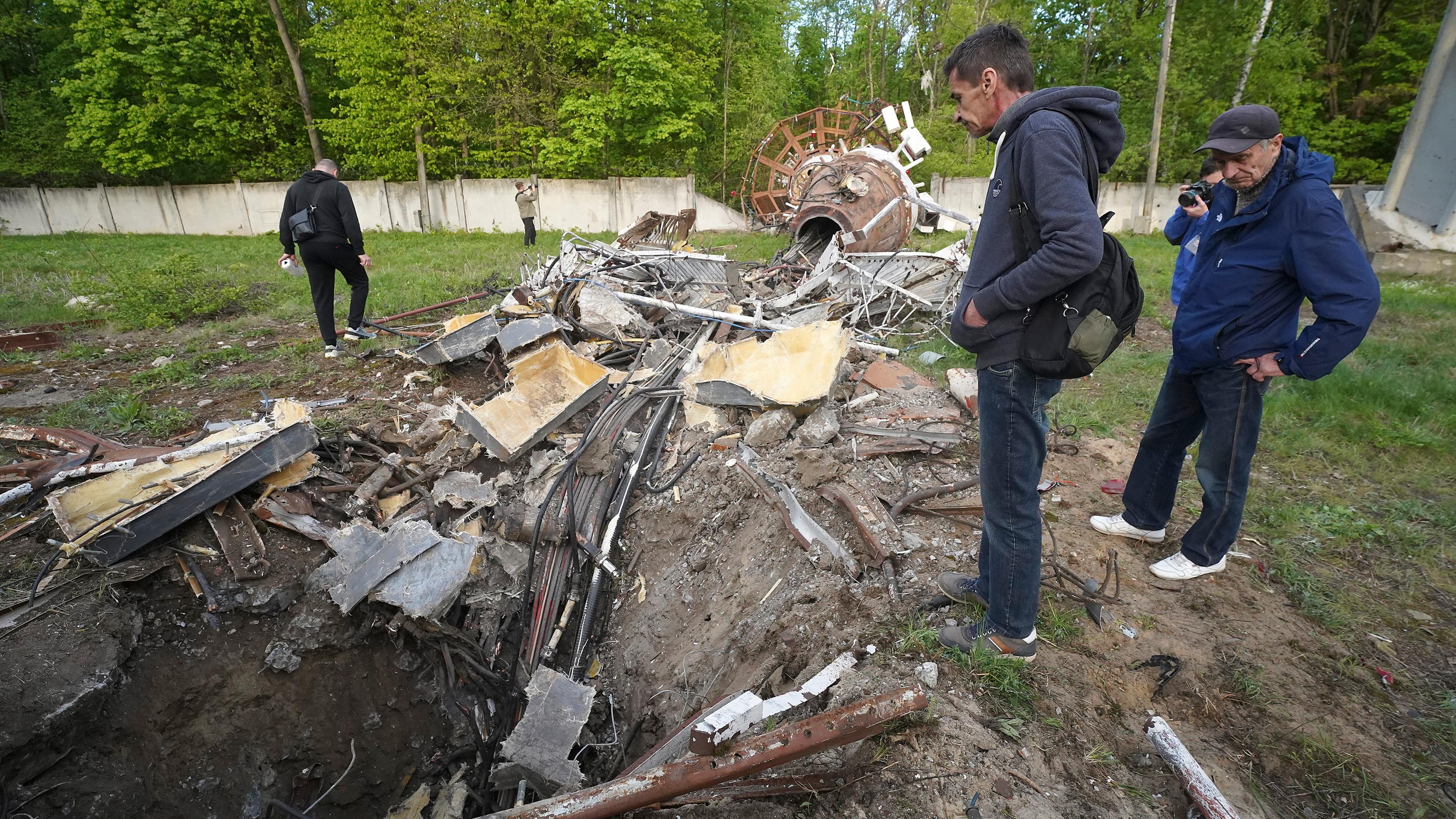 Menschen betrachten Fragmente des Fernsehturms, der nach dem Einschlag einer russischen Rakete in Charkiw, Ukraine, am 22.04.2024, in zwei Hälften zerbrochen wurde