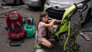 Polina, 10, kümmert sich um ihre Schwester Marina, 3, an der Stelle des von russischen Raketen getroffenen Kinderkrankenhauses Okhmatdyt in Kiew (Ukraine)