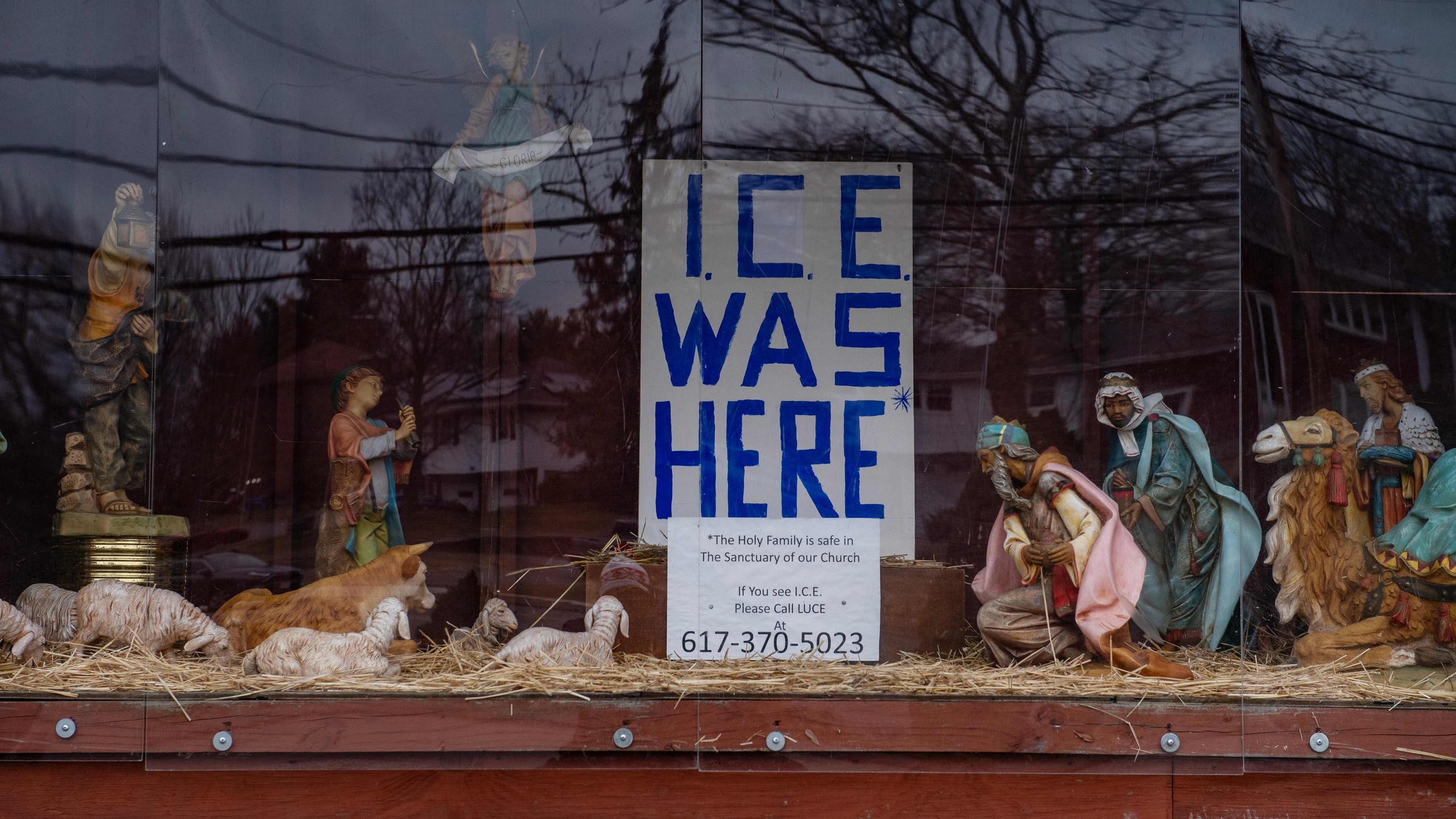 Die Saint Susanna Parish Kirche, in Dedham, Massachussets, zeigt am 23.12.2025 eine Krippenszene mit einem Schild "ICE was here" ("Die Einwanderungsbehörde war hier") an der Stelle, an der normalerweise das Jesukind in der Krippe liegen würde.