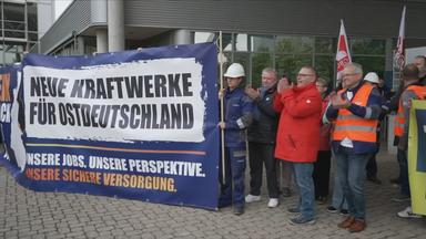 Beschäftigte halten Banner hoch